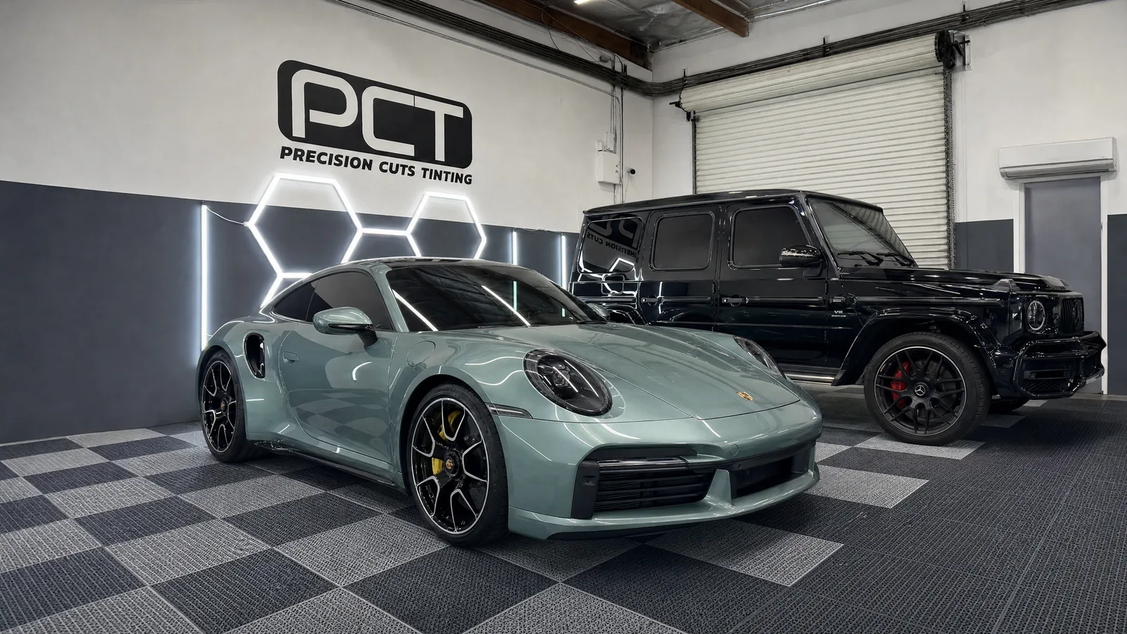 A pale teal Porsche 911 Turbo S and a black Mercedes-AMG G63, freshly tinted, in the Precision Cuts Tinting studio in Yorba Linda