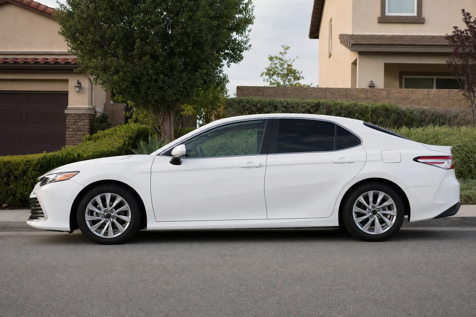 A white car side-on: the front side windows clear, the rear side windows and back window dark, a narrow strip across the top of the windshield